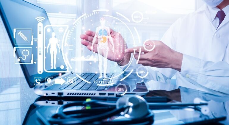 In_the_medical_office,_the_doctor_is_working_on_a_laptop_computer_for_health_records._The_idea_is_to_assess_and_care_for_patients'_health_online.