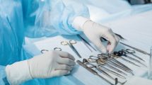 nurse_in_sterile_gloves_choosing_tool_to_perform_surgery._close_up_cropped_photo.job,_profession,_occupation