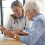 Elderly_woman_with_nurse_at_home_looking_at_tablet
