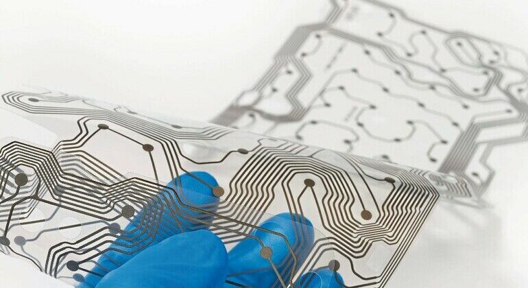 Transparent_plastic_membrane_with_brown_copper_layer_PCB._Bending_of_patterned_silicone_sheet._Electronics_industry._Selective_focus