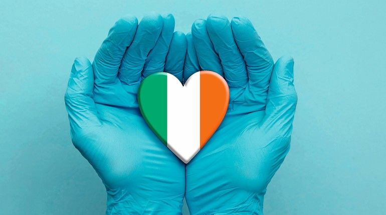 Doctors_hands_wearing_surgical_gloves_holding_Ireland_flag_heart.