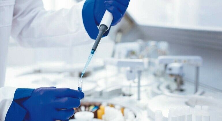 Parental_test._Hands_in_blue_gloves_holding_pipette_and_test_tube_with_poured_blue_chemical__which_placed_on_blurred_background