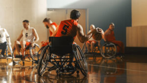 Wheelchair_Basketball_Game_Court:_Active_Professional_Player_Dribbling_Ball,_Prepairing_to_Shoot_and_Score_a_Goal._Determination,_Inspiration,_and_Skill_of_a_People_with_Disability.