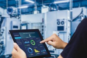 Smart_industry_control_concept.Hands_holding_tablet_on_blurred_automation_machine_as_background