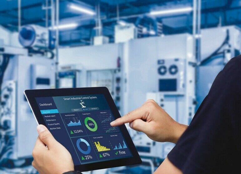 Smart_industry_control_concept.Hands_holding_tablet_on_blurred_automation_machine_as_background