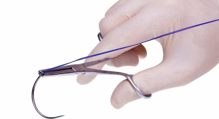 surgical__forceps__holding_a_suture_needle